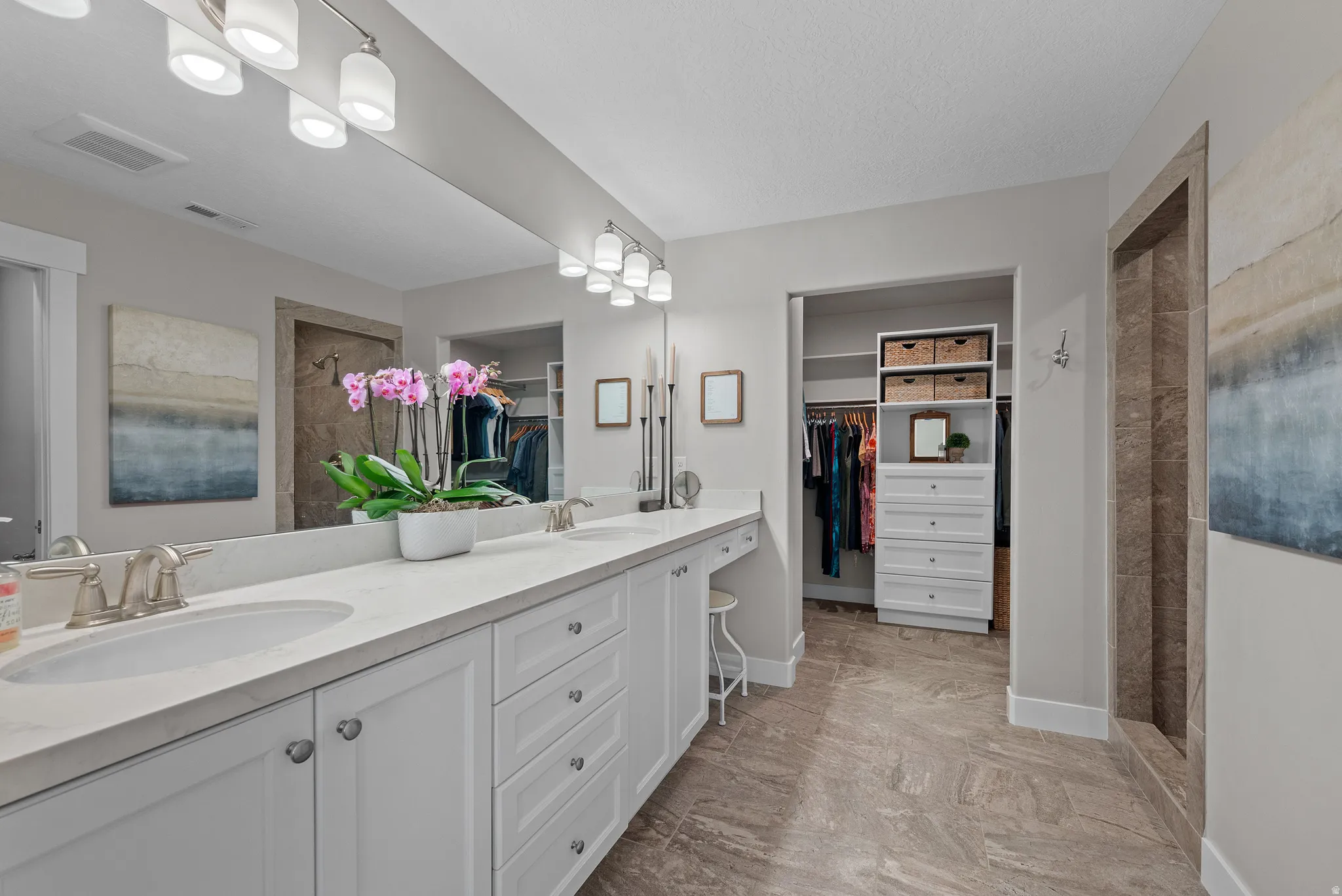 Beautiful master bath with oversized walk in shower, double vanity, and a spacious closet with custom built-in’s