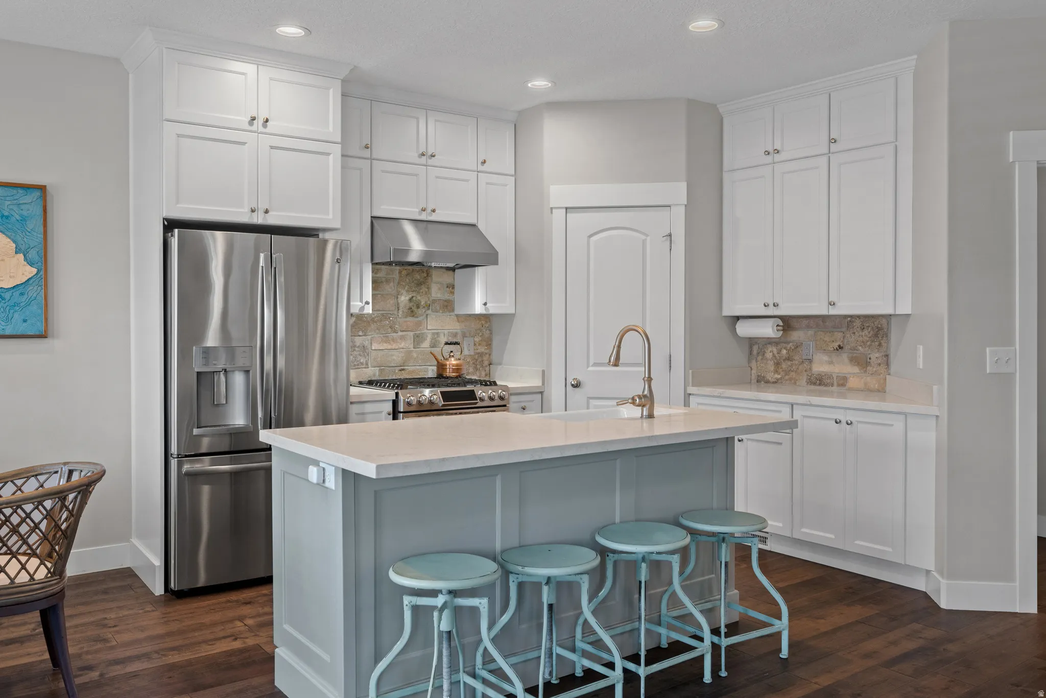 Extraordinarily updated stainless steel appliances, white cabinets to the ceiling, natural stone backsplash.