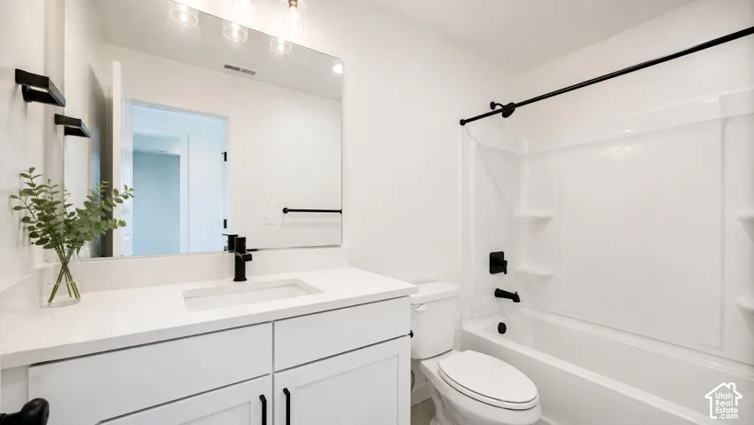 White vanity with an integrated sink and matte black faucet, wall-mounted mirror with overhead lighting, and a white tub with a matte black shower head and fixtures