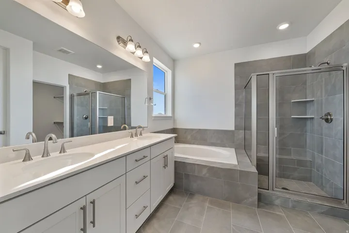 Primary Bathroom featuring double vanity, a shower stall, a bath, light tile patterned floors, and recessed lighting