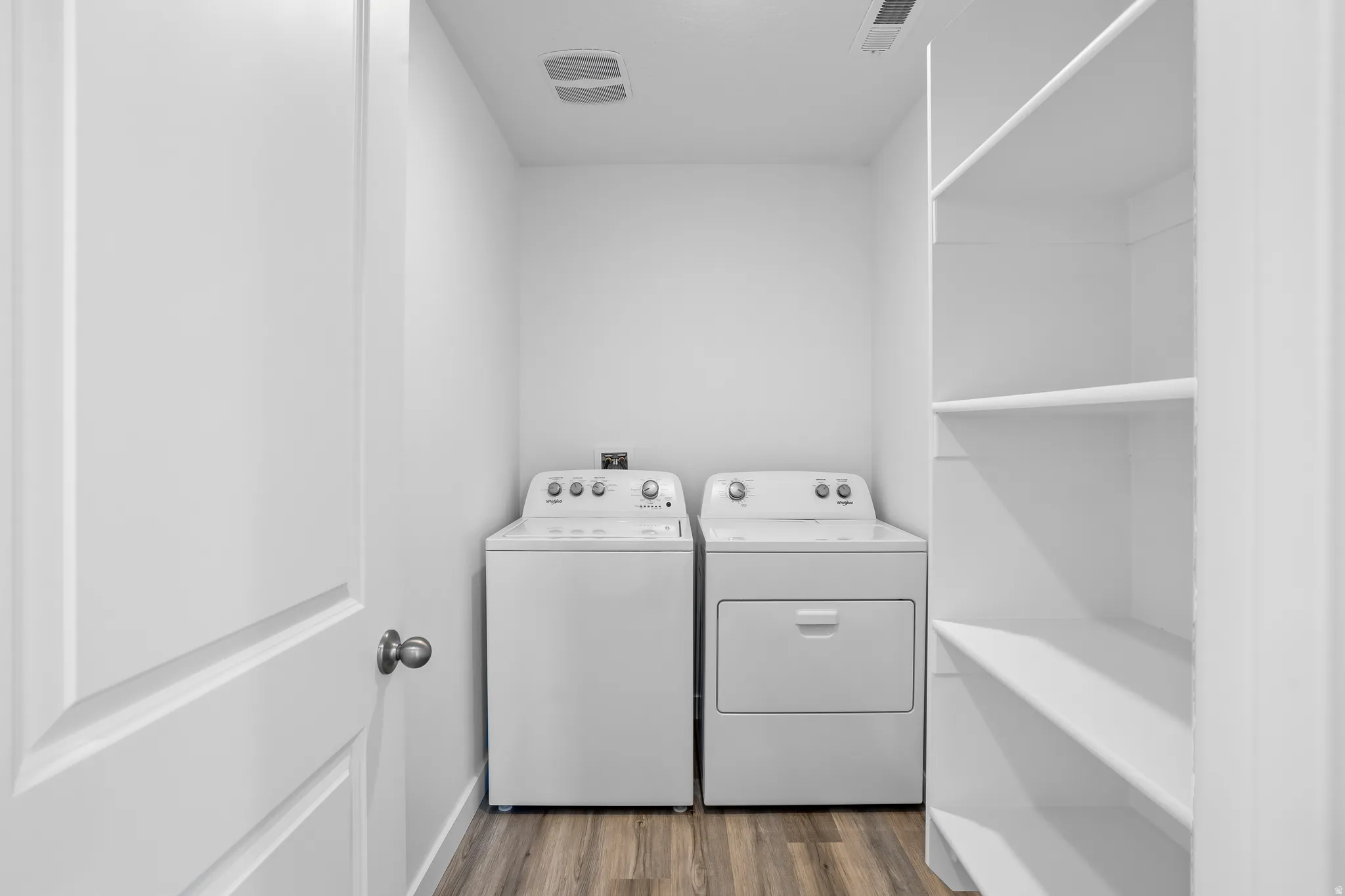 Laundry room featuring dark wood finished floors and washing machine and dryer