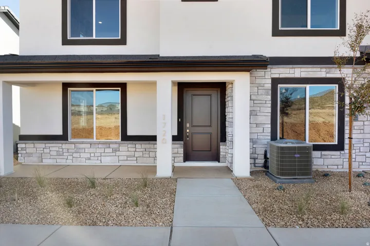 Photos of similar home and plan.Doorway to property featuring stone siding and stucco siding