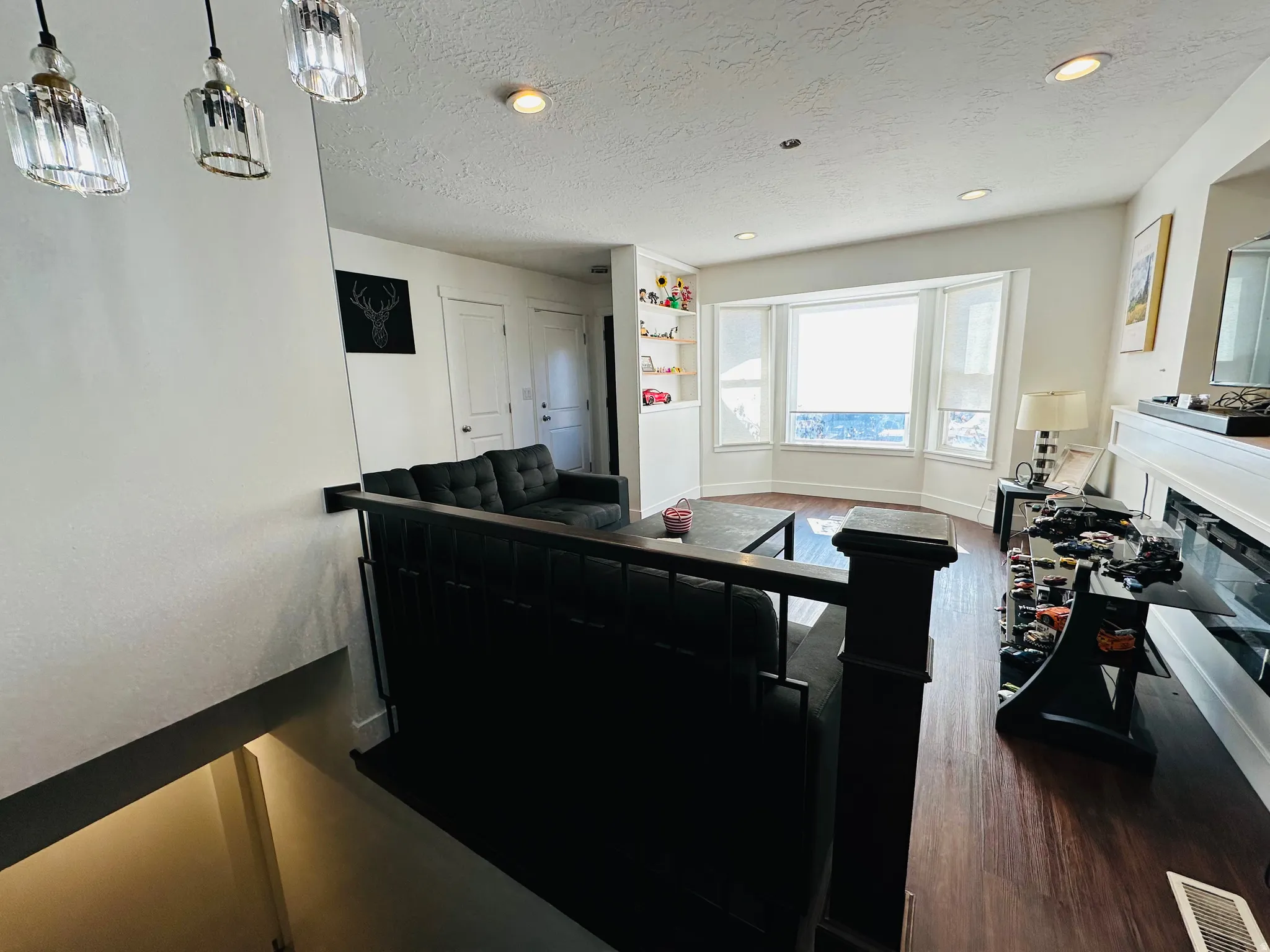 Kitchen featuring a textured ceiling, dark wood-style floors, a glass covered fireplace, and hanging light fixtures
