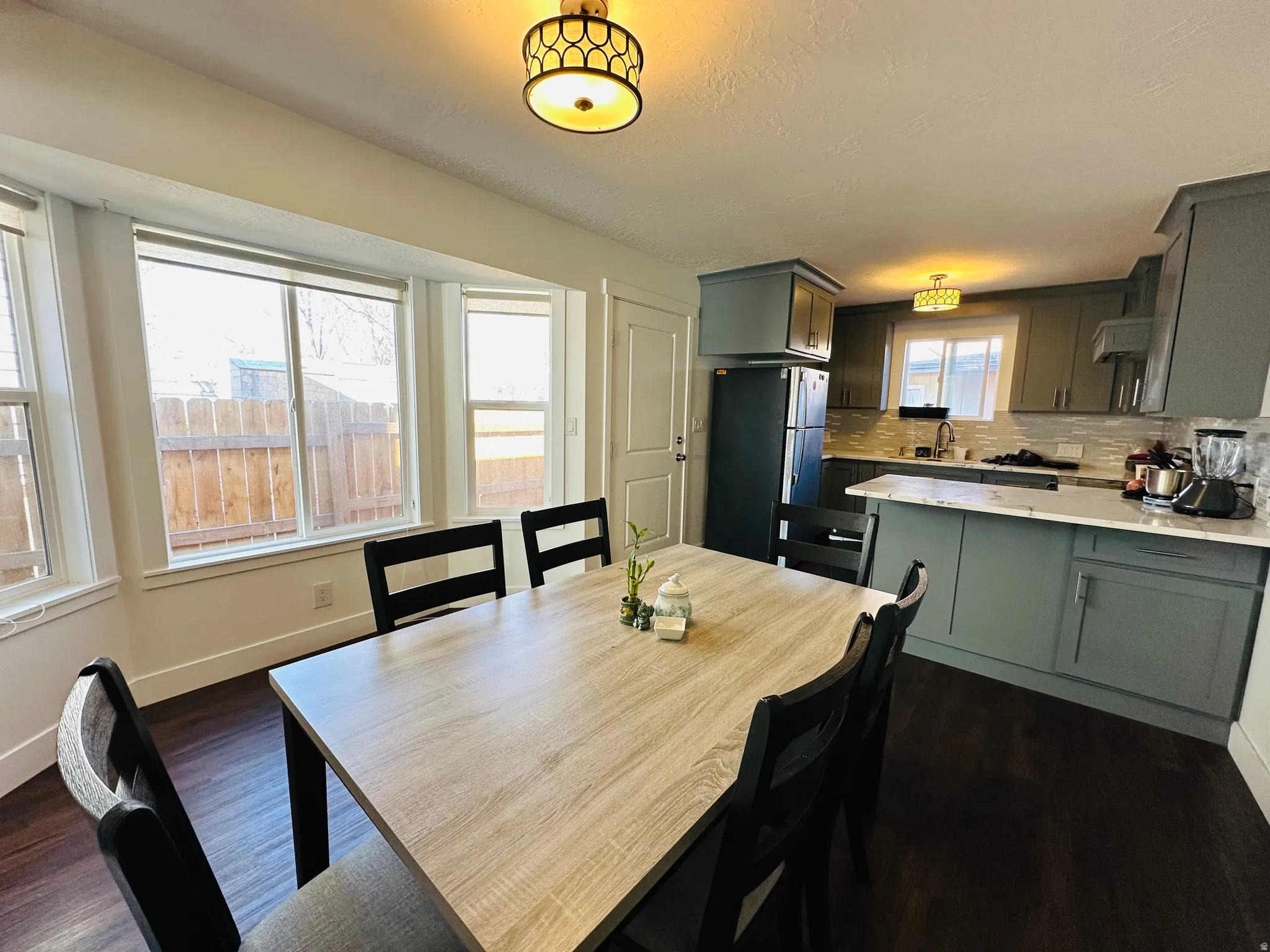Dining area featuring dark wood-style floors and a textured ceiling