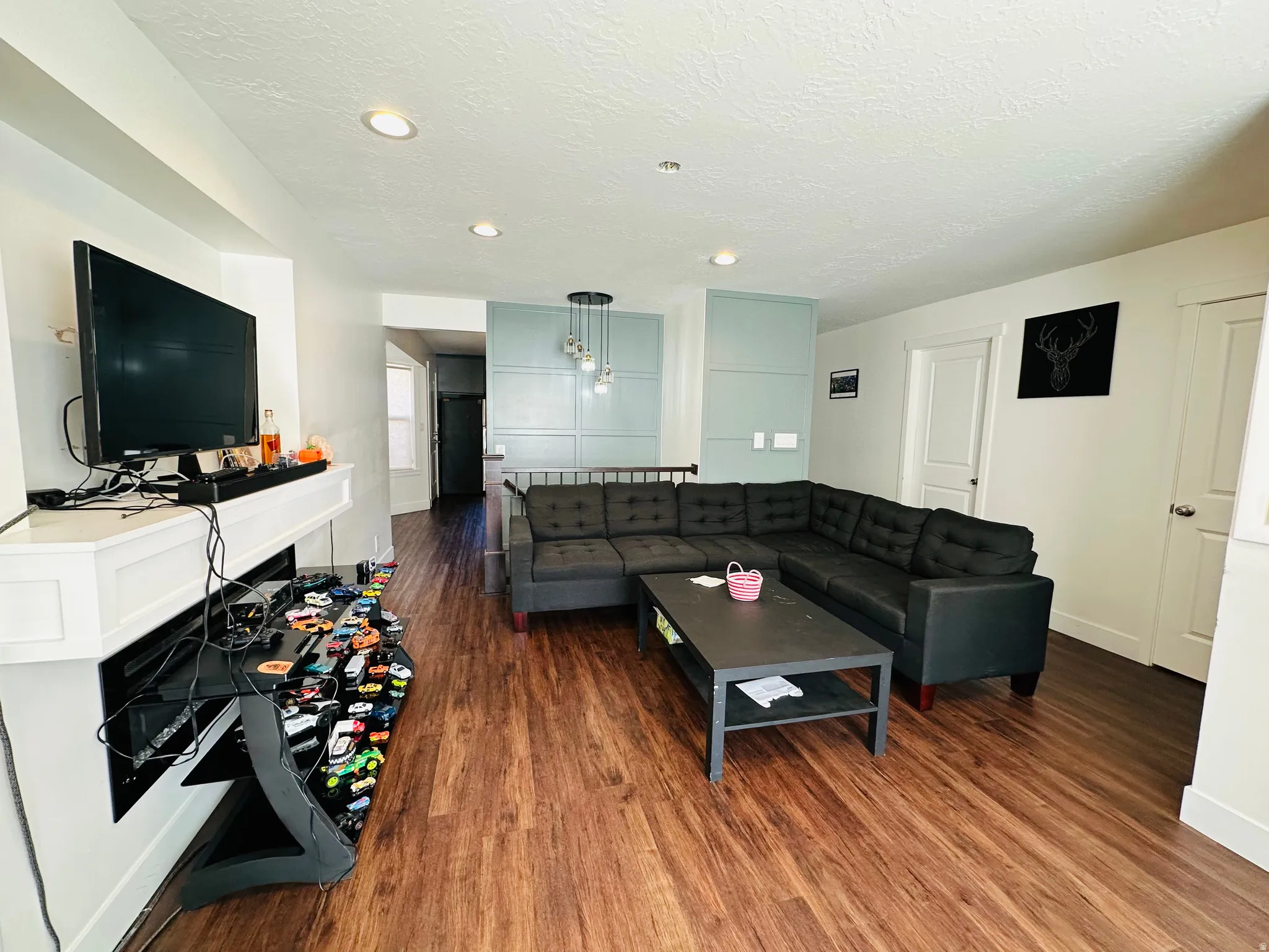 Living area featuring dark wood-type flooring and a textured ceiling