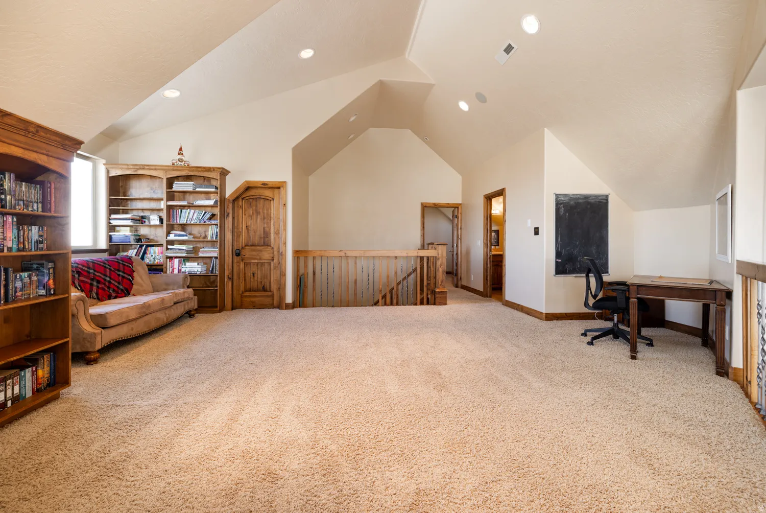 Home office with light colored carpet, lofted ceiling, and recessed lighting