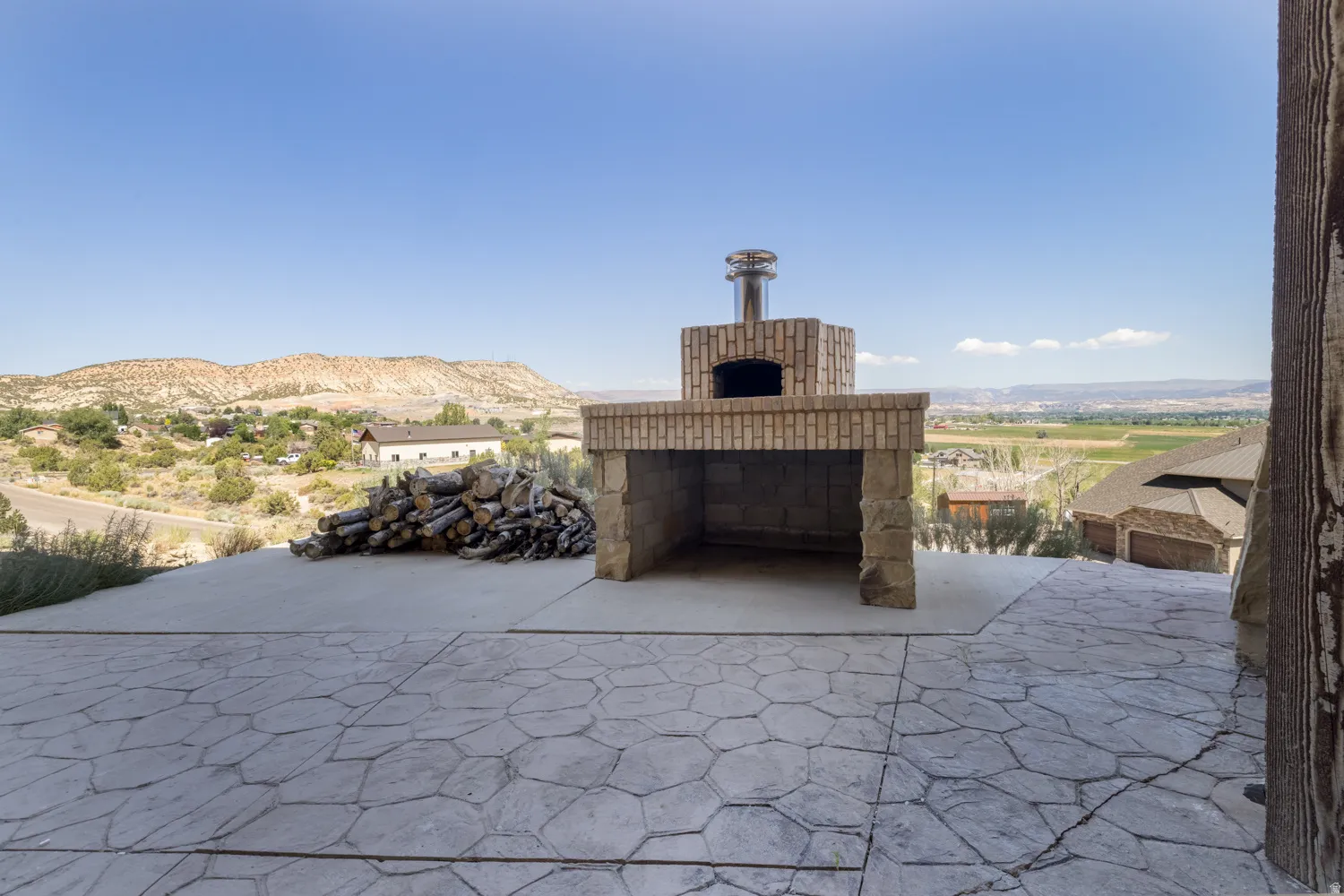 View of patio featuring a mountain view and exterior fireplace