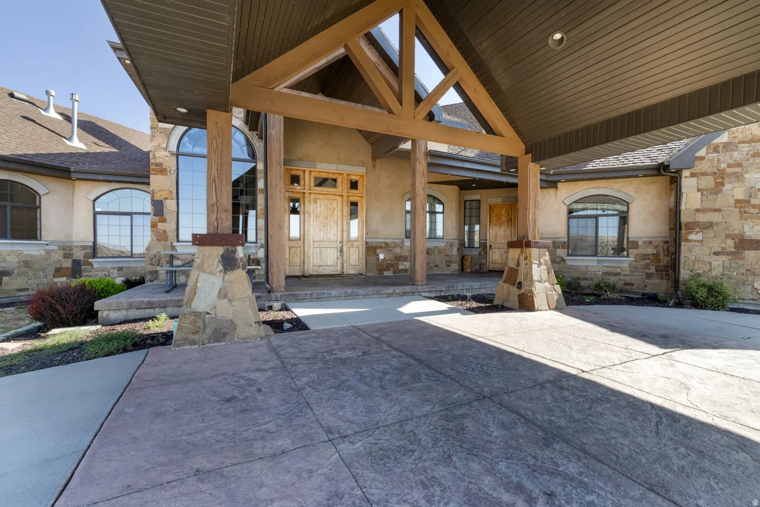Property entrance with stone siding and stucco siding