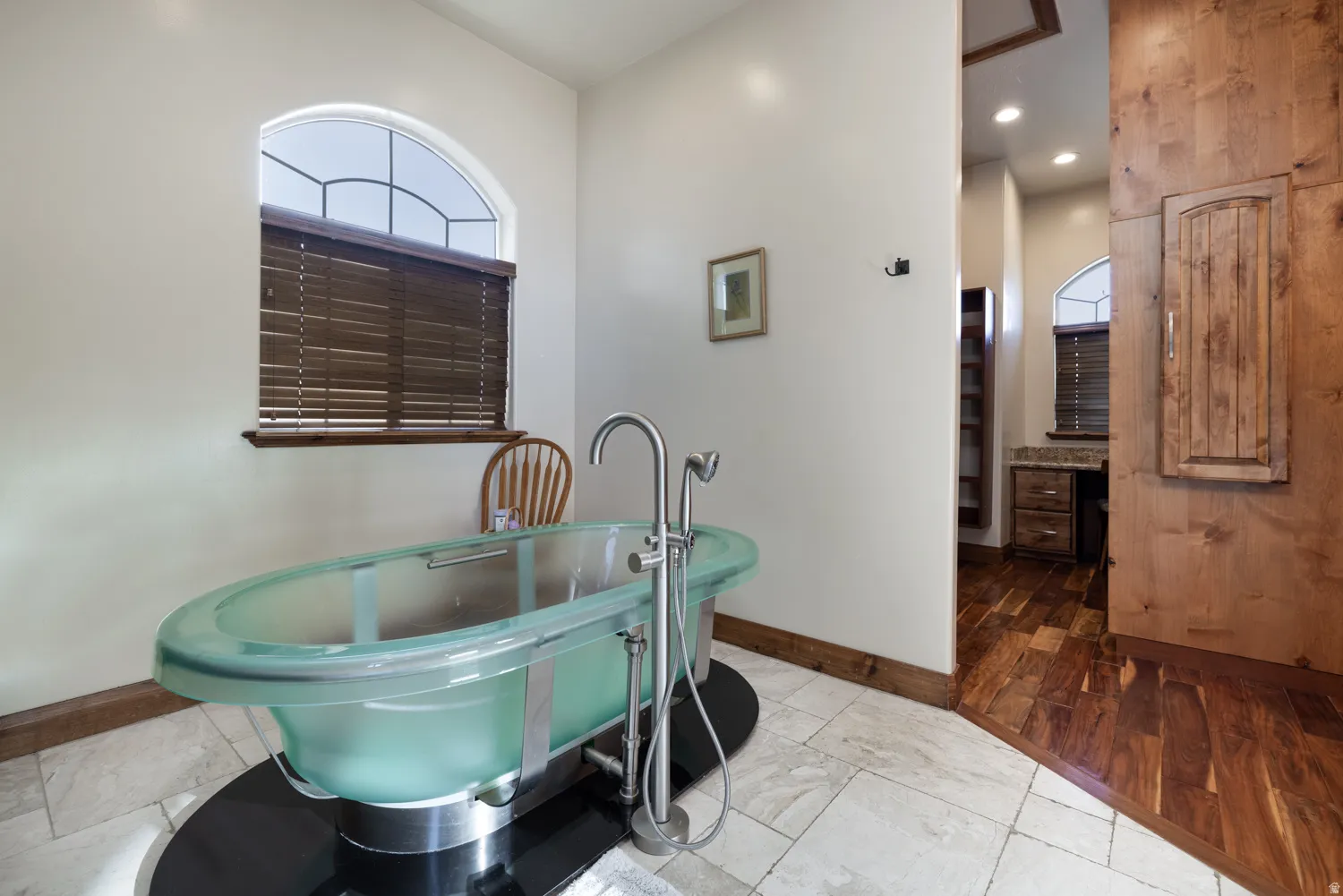 Bathroom with a soaking tub and baseboards