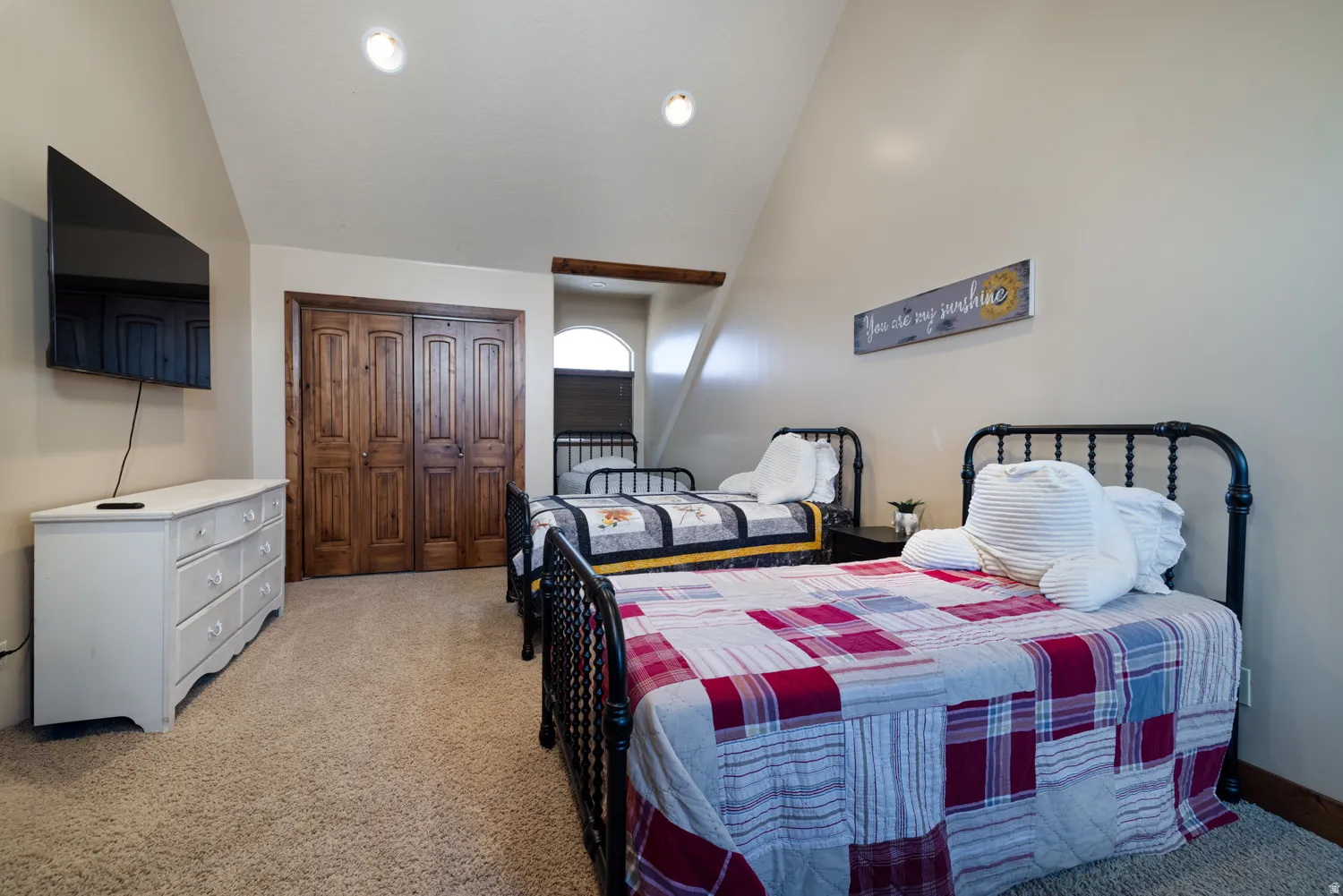Bedroom featuring vaulted ceiling, light colored carpet, and a closet