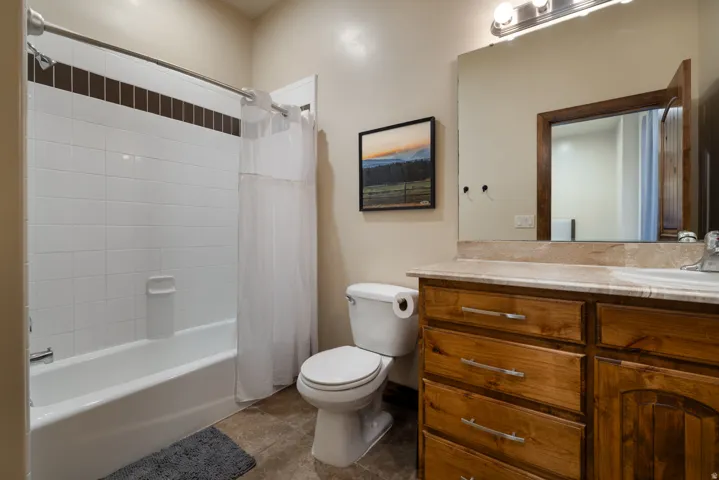 Bathroom featuring vanity and shower / bath combo with shower curtain