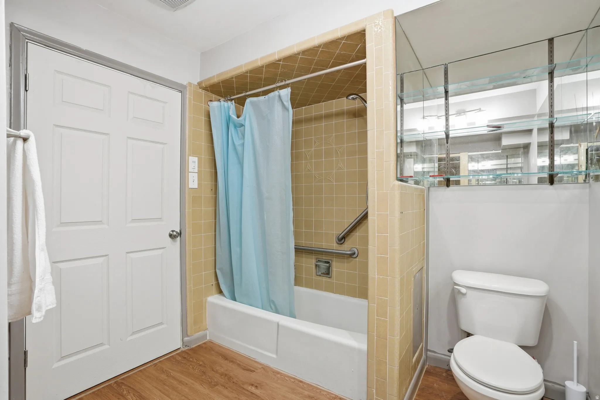 Bathroom with shower / bath combination with curtain and wood finished floors