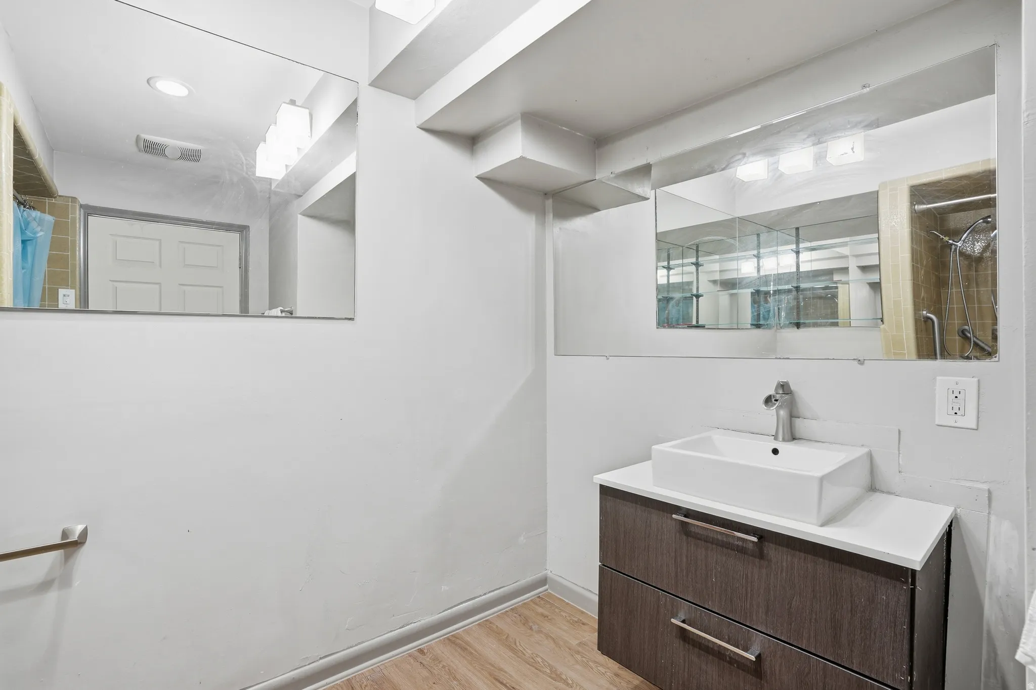 Full bath featuring vanity, light wood-type flooring, and a shower with shower curtain