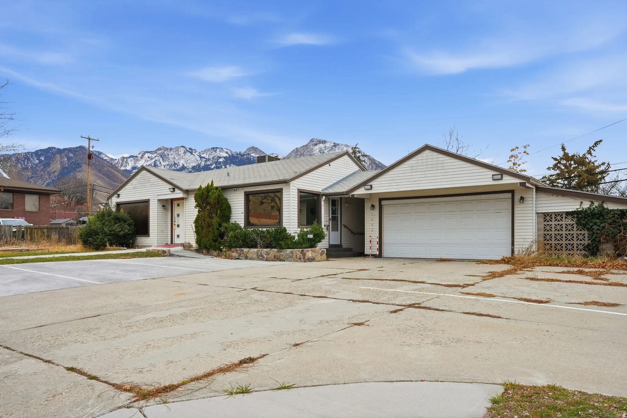 Ranch-style home featuring an attached garage, concrete driveway, and a mountain view
