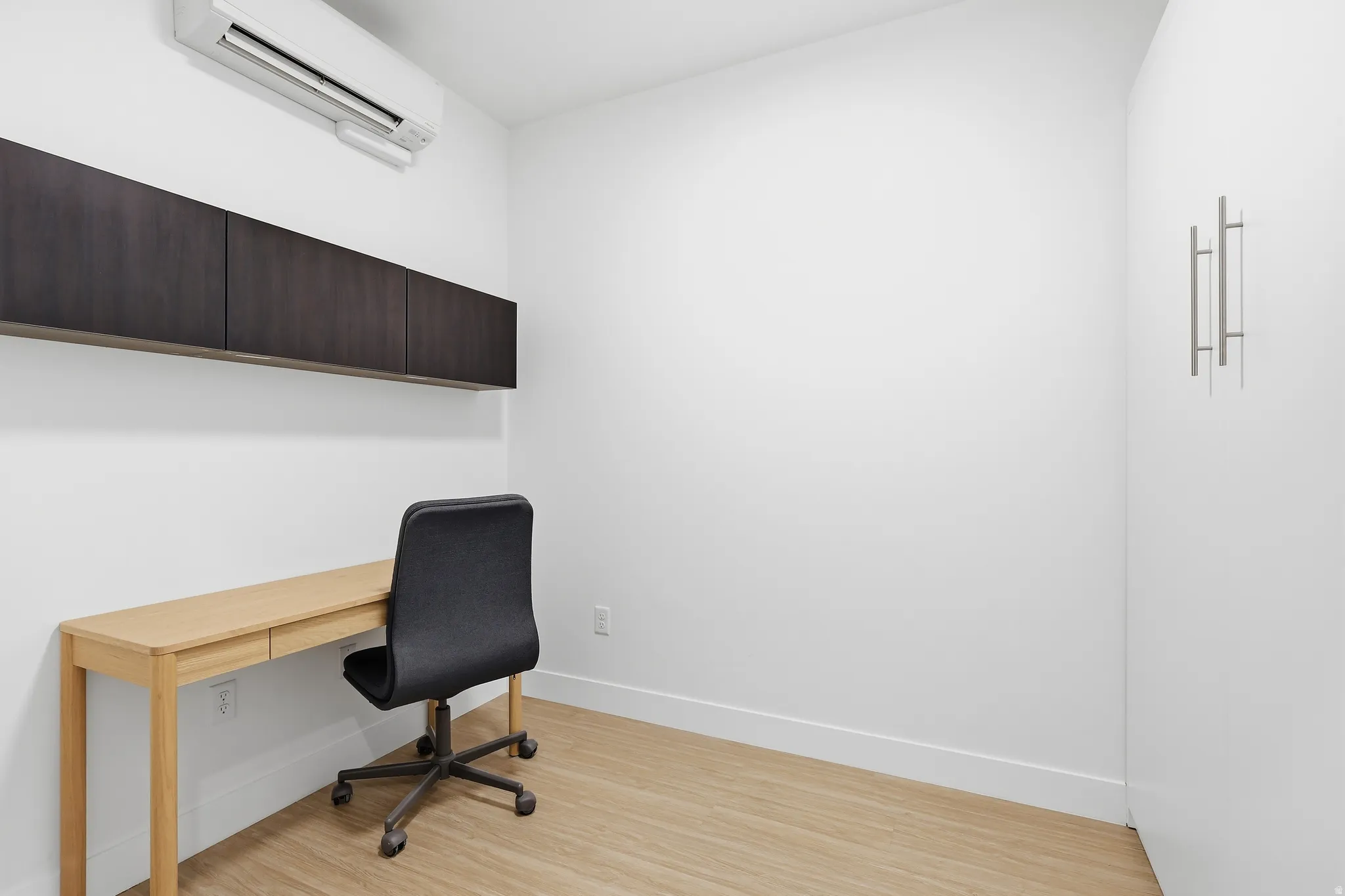 Office by day  featuring a mini split for heating / cooling and light wood-style flooring