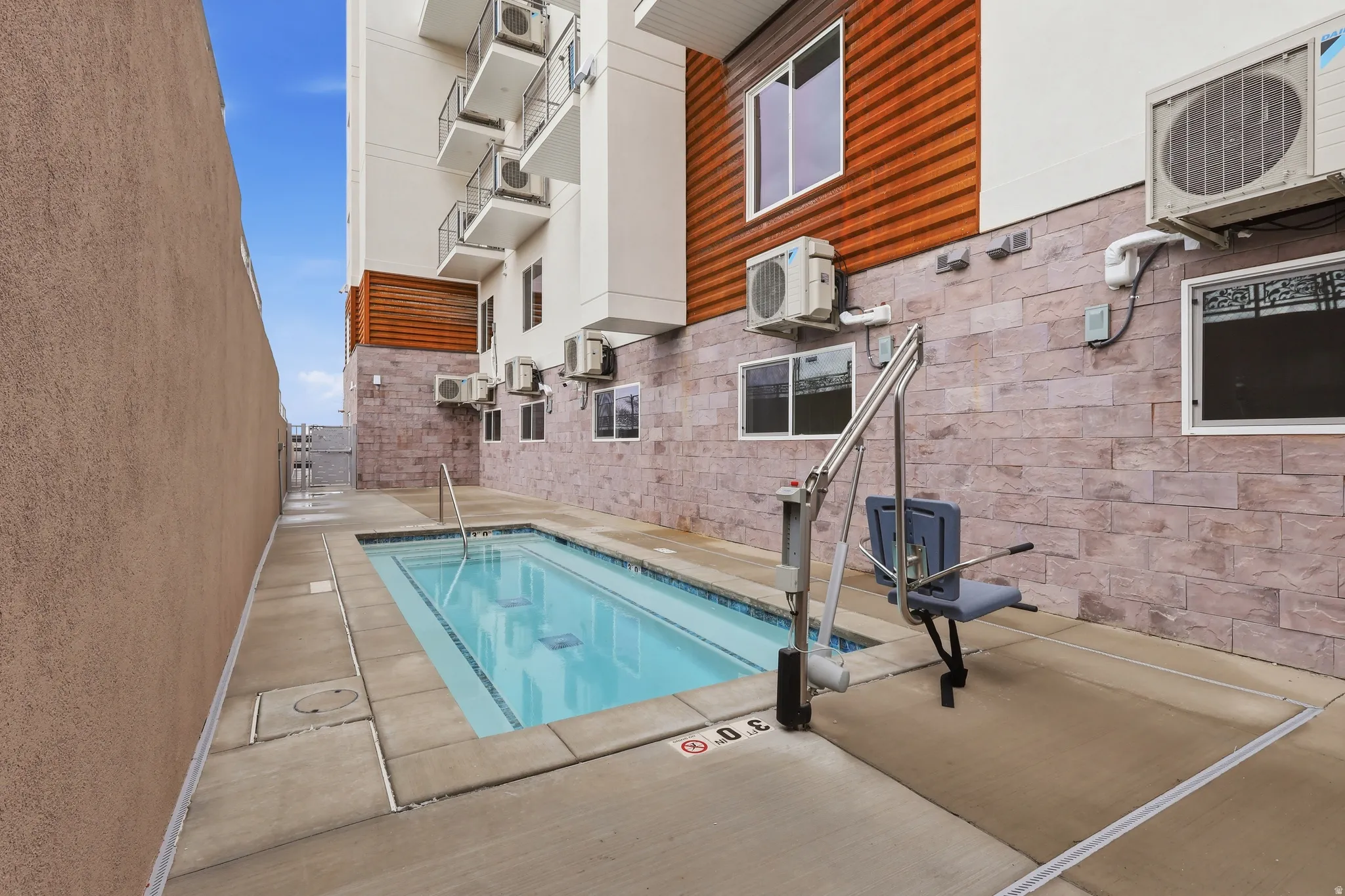 View of heated spa featuring a swimming pool and patio surround