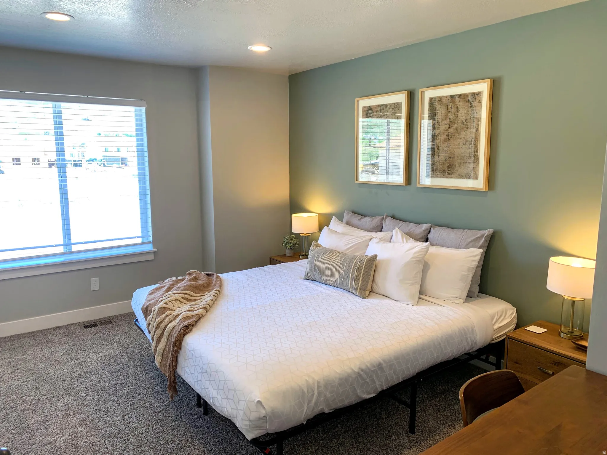Carpeted bedroom featuring multiple windows and recessed lighting