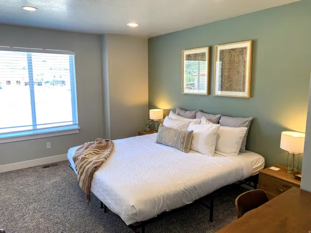 Carpeted bedroom featuring multiple windows and recessed lighting
