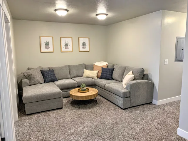 Carpeted living area with electric panel and a textured ceiling