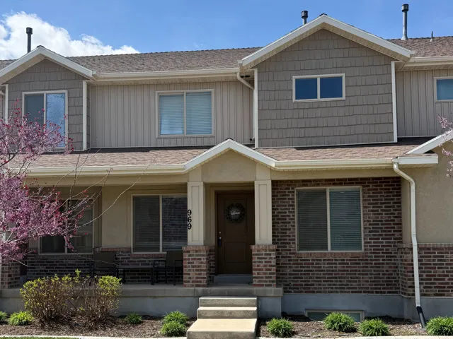 Craftsman-style house with a front lawn, a porch, brick siding, and a shingled roof
