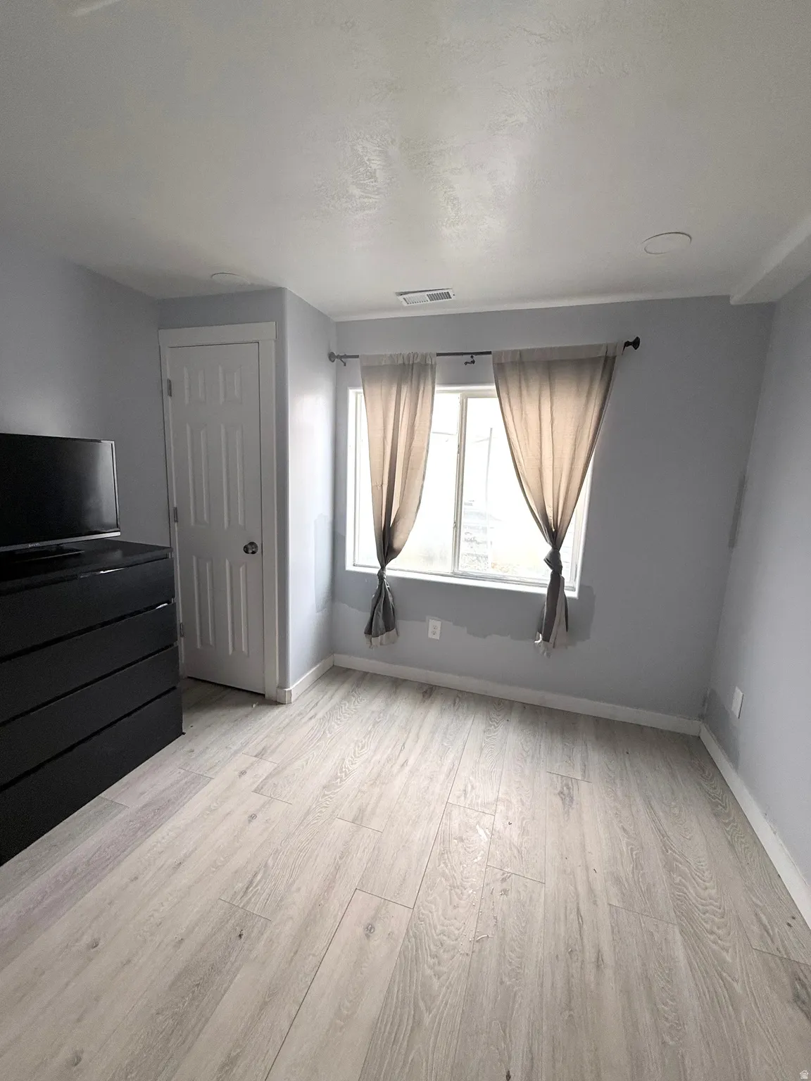 Unfurnished bedroom featuring light wood finished floors and a closet