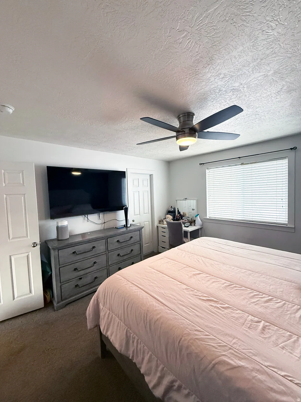 Bedroom featuring carpet floors, a textured ceiling, and a ceiling fan