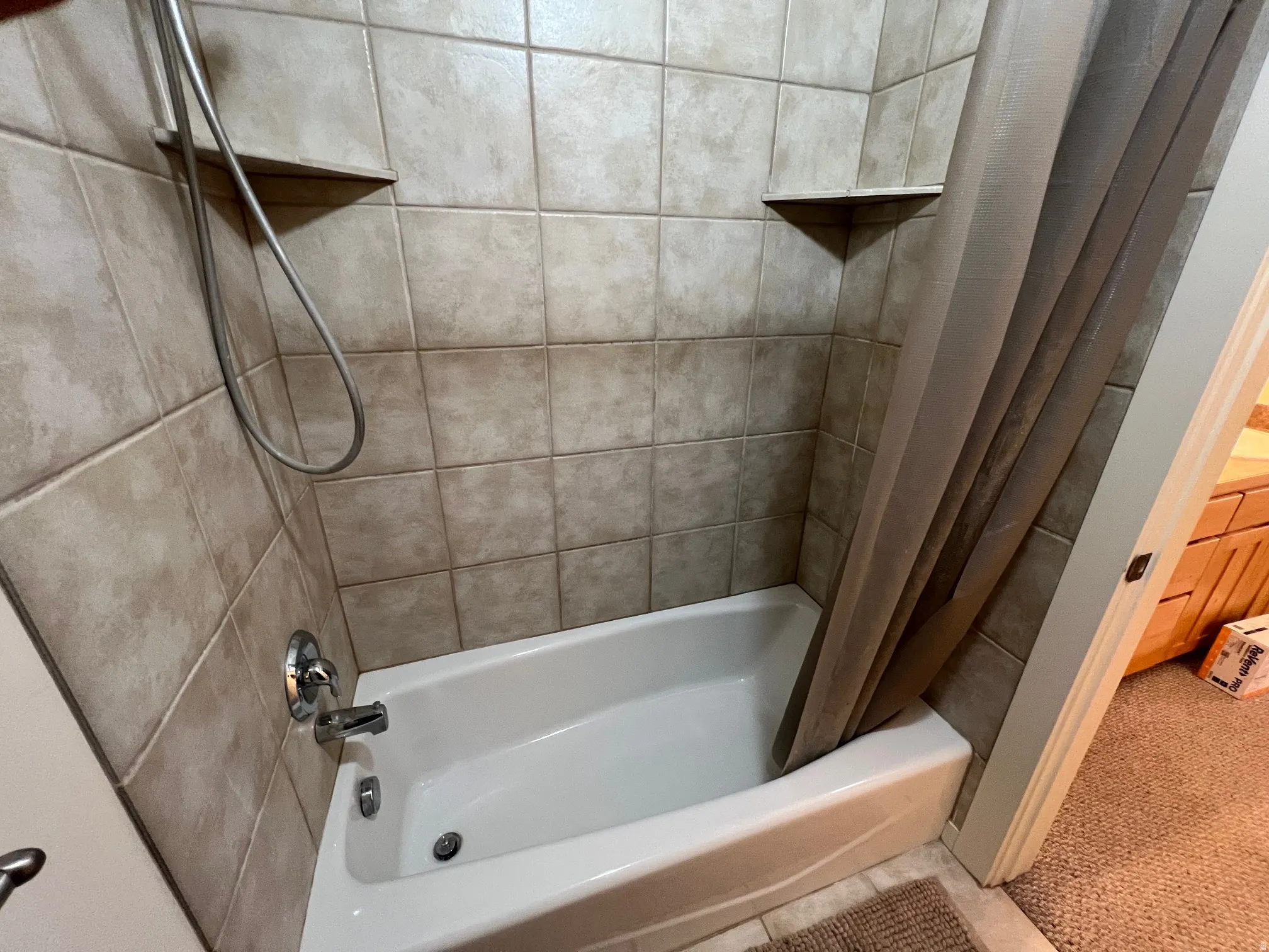 Bathroom with shower / bath combination with curtain and tile floors.