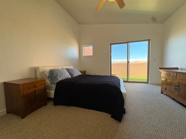 Bedroom featuring light carpet, vaulted ceiling, access to deck.  Spacious and room for any size bed.