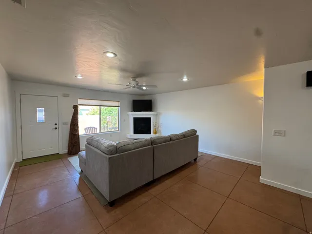 Open-concept living area featuring a corner fireplace, recessed lighting, and a ceiling fan
