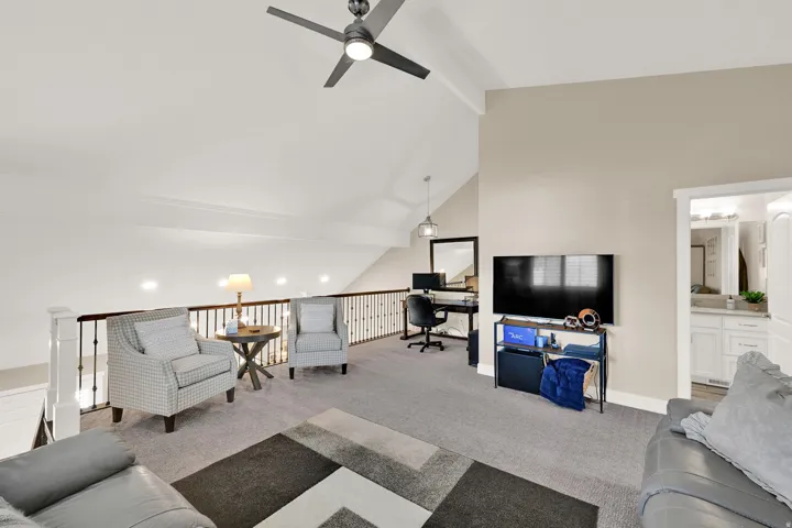 Living room with an office area, beamed ceiling, carpet, high vaulted ceiling, and a ceiling fan
