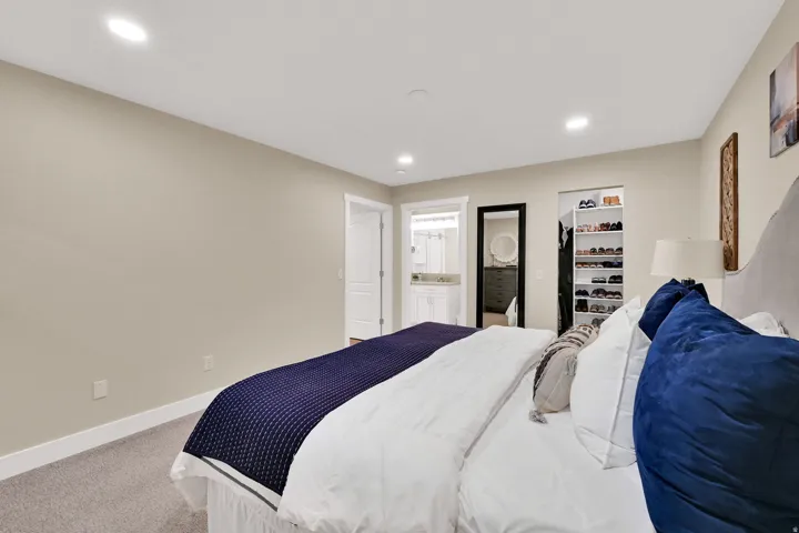 Bedroom with light colored carpet, recessed lighting, and ensuite bathroom