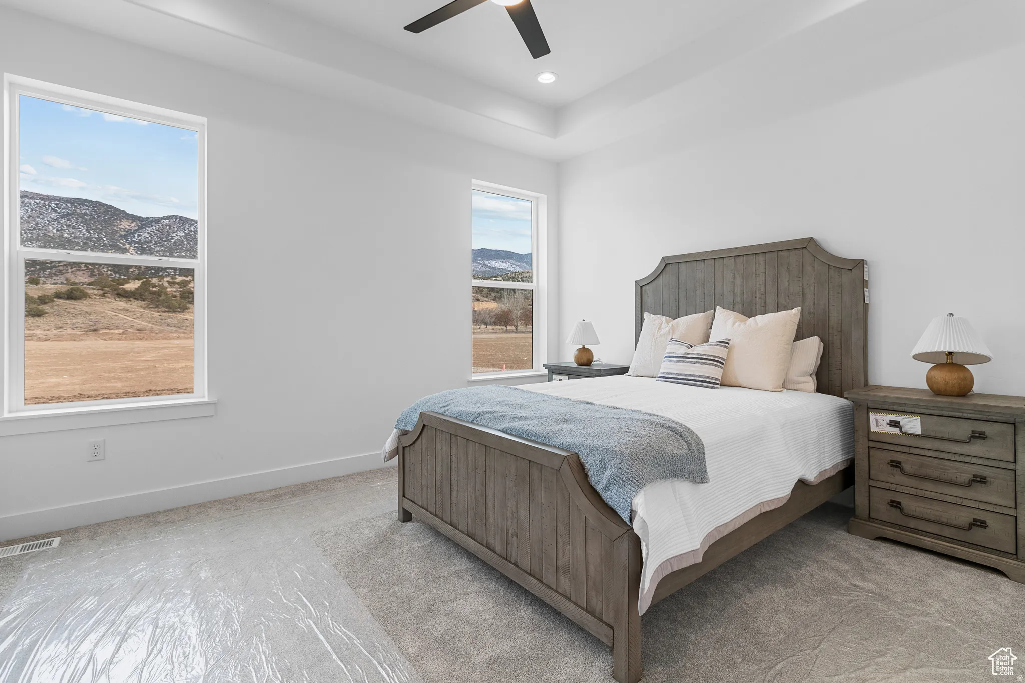 Carpeted bedroom with a mountain view and ceiling fan