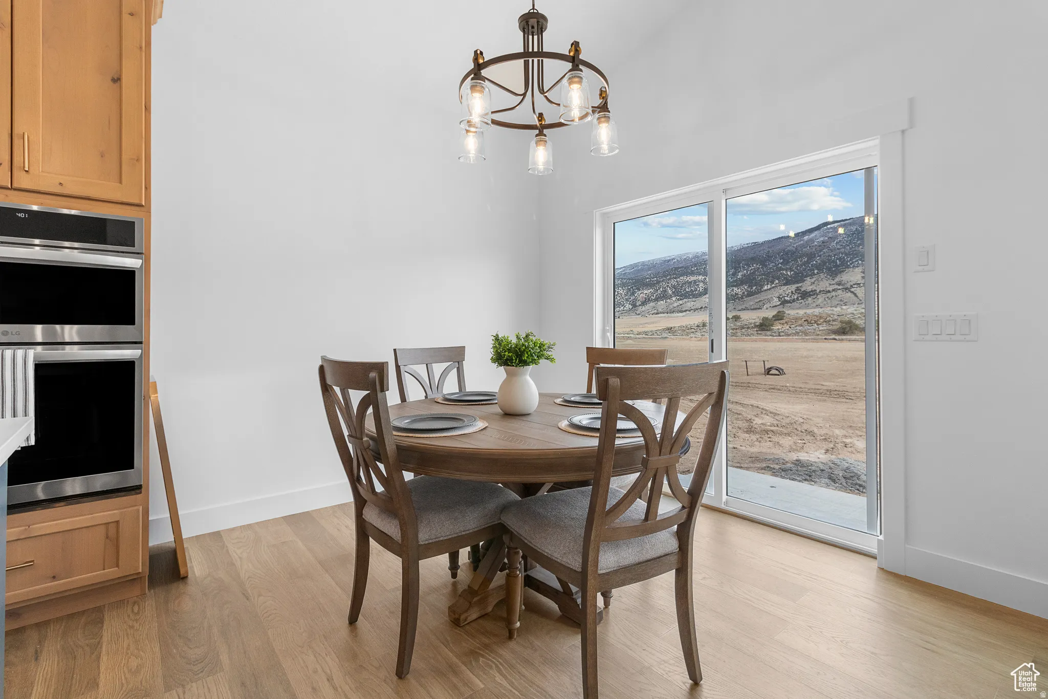 Dining area featuring a chandelier, light wood-style flooring, and a mountain view