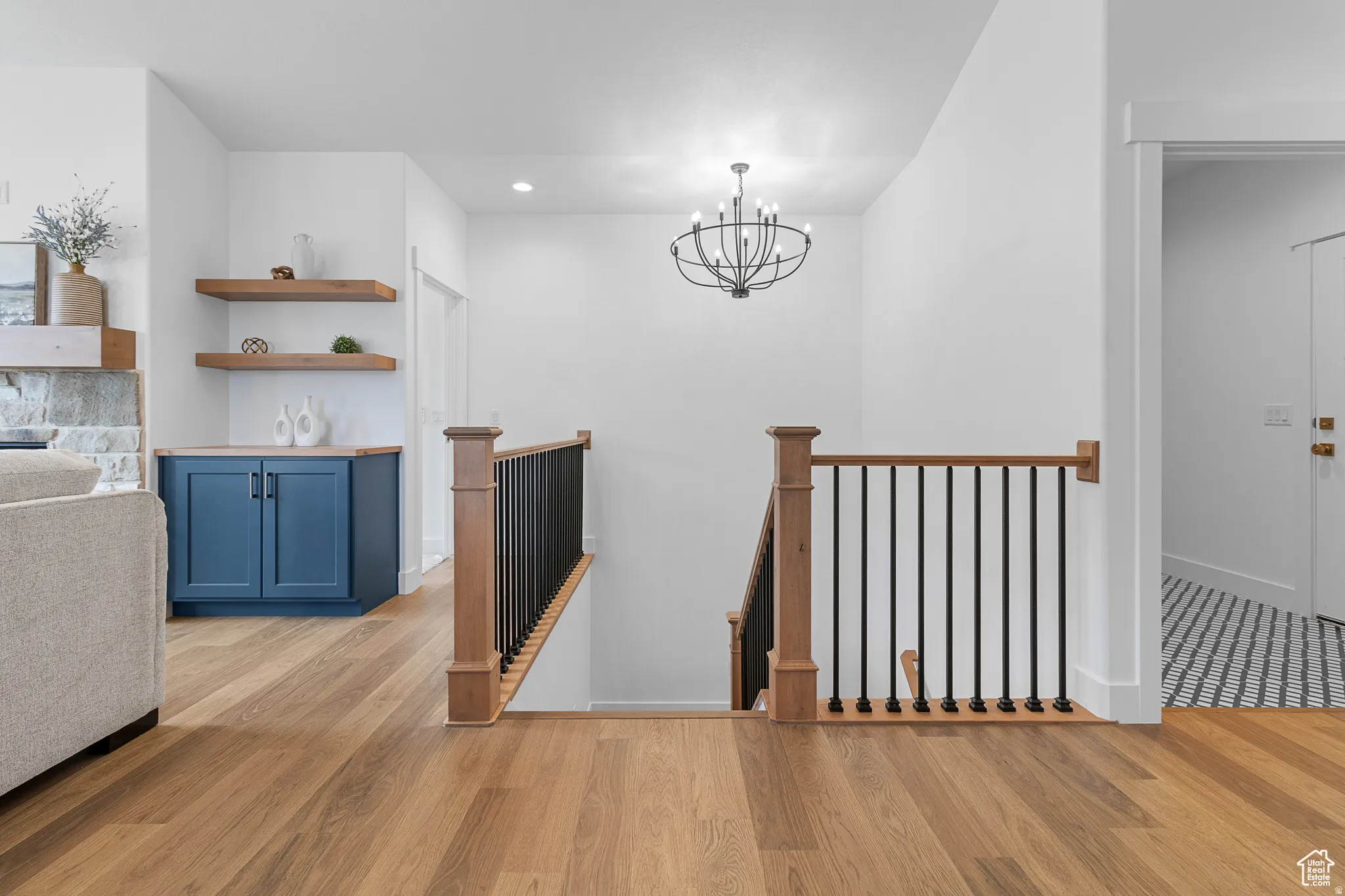 Stairway with wood finished floors and a chandelier