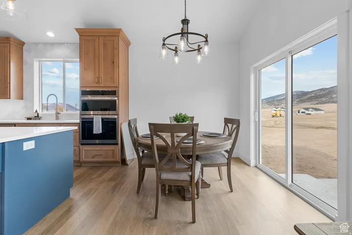Dining room featuring hanging lights, dark wood-style flooring, and a mountain view