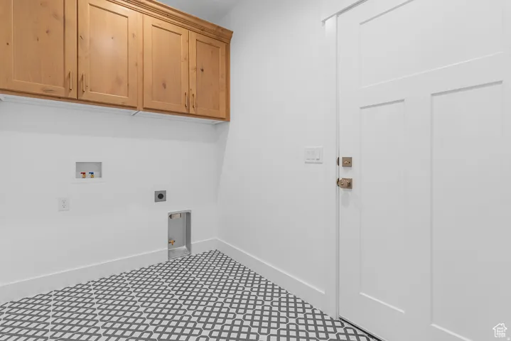 Laundry area featuring hookup for an electric dryer, cabinet space, and hookup for a washing machine