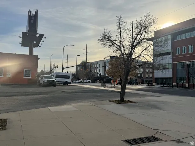 View of asphalt road with sidewalks and street lights