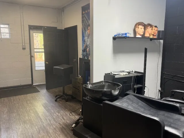 Miscellaneous room featuring concrete block wall and dark wood finished floors