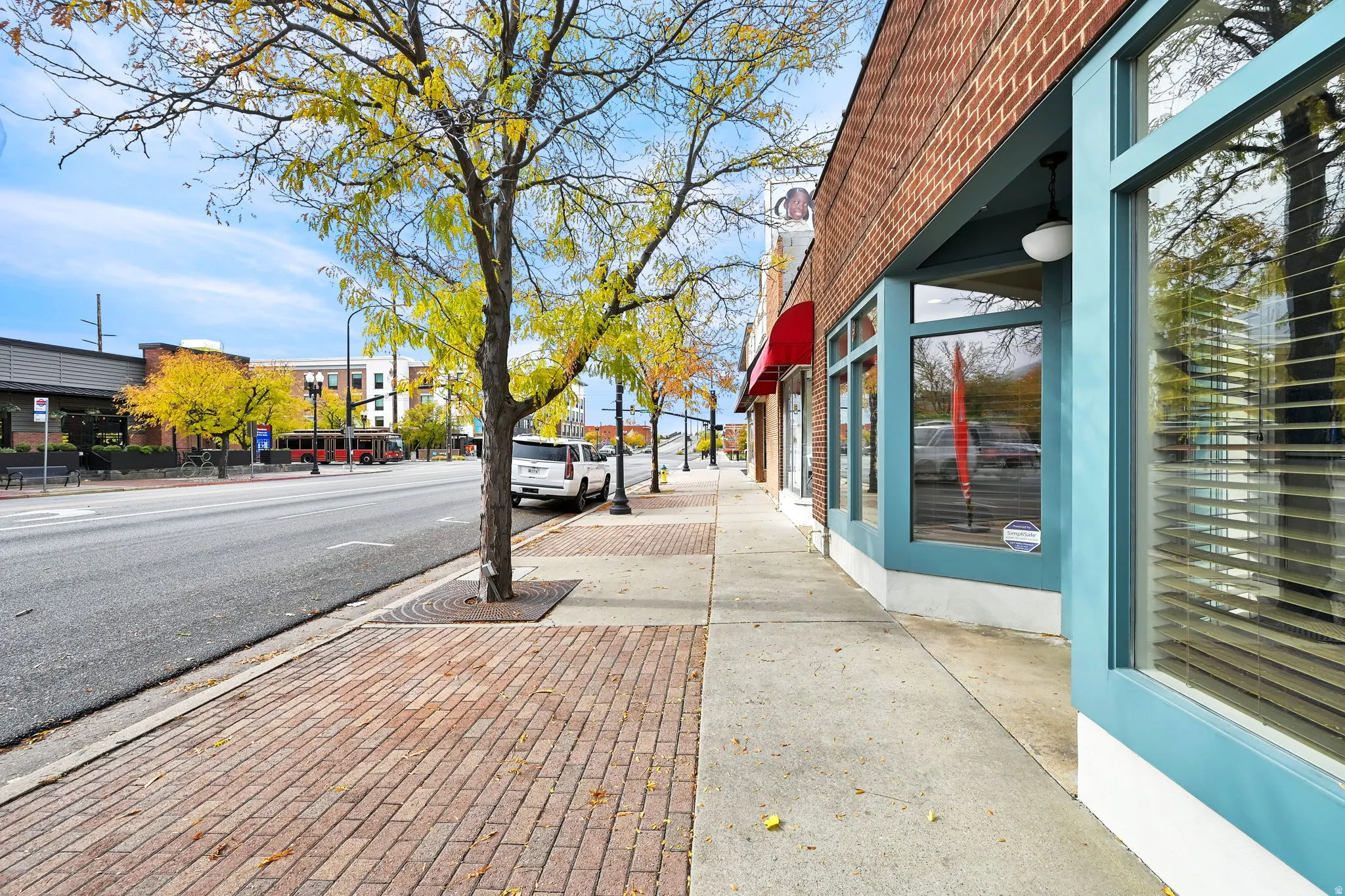 View of asphalt street with sidewalks, curbs, and street lights