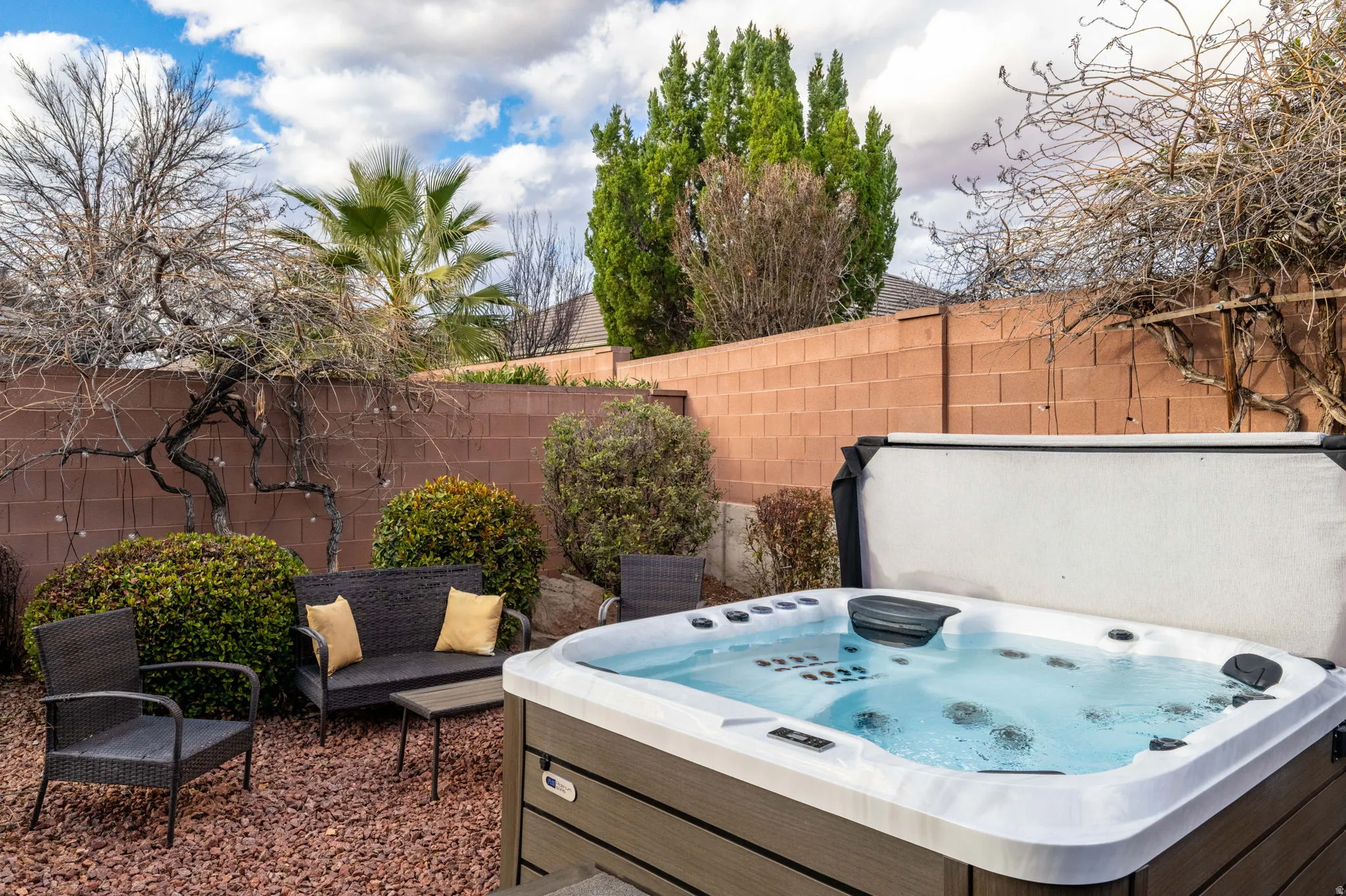 Fenced backyard with a patio area and a hot tub
