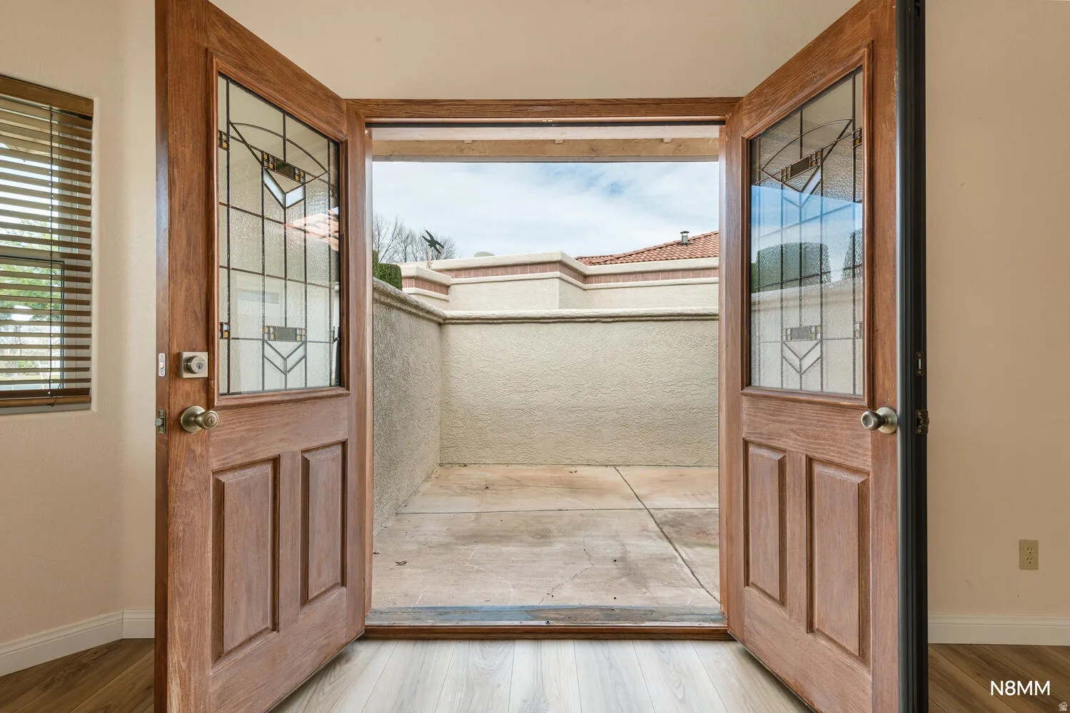 Primary bedroom private entryway from private courtyard with wood finished floors