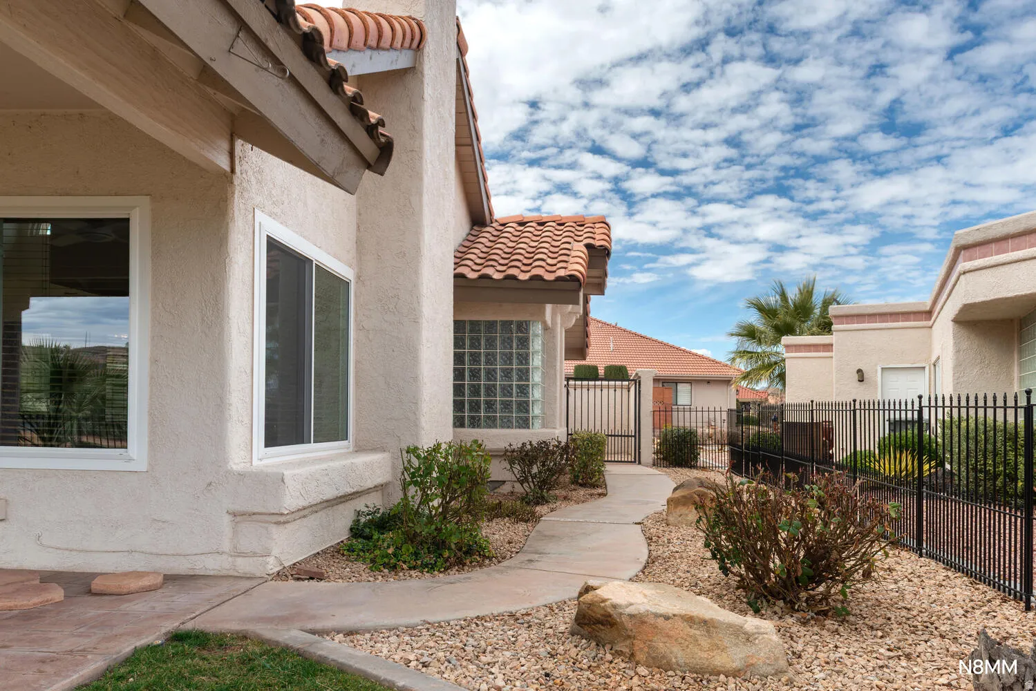 View of home's north exterior featuring a tile roof and fenced yards