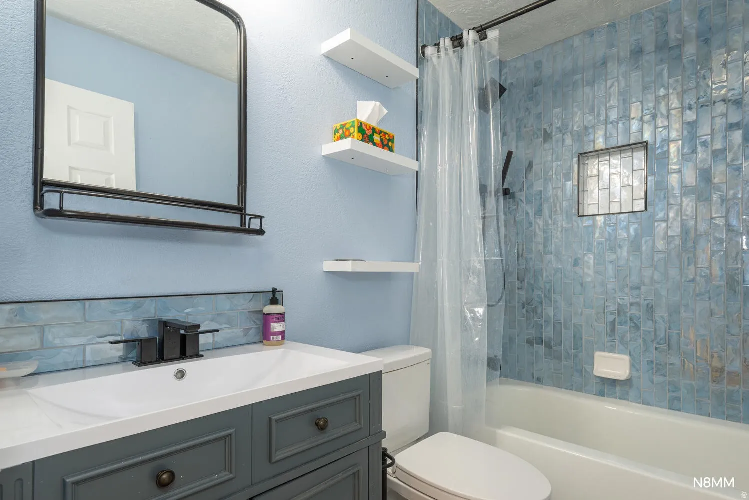 Second bath with shower / bath combo, vanity, a textured wall, and a textured ceiling