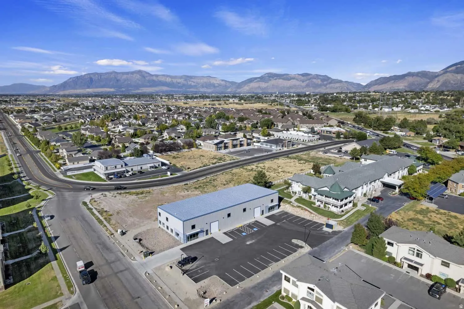 Aerial overview of property's location with a mountainous background and nearby suburban area
