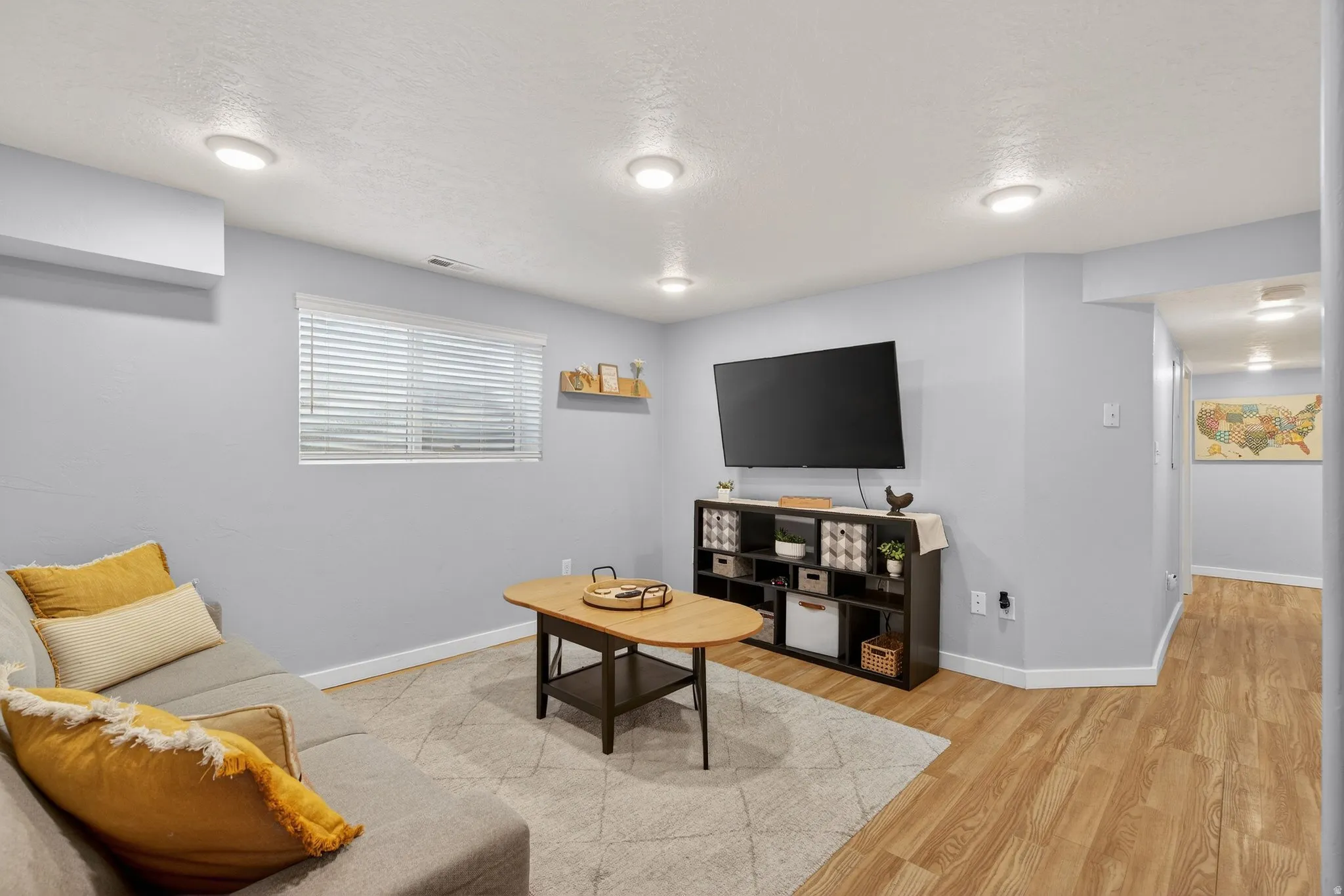 Living area featuring light wood-style flooring and a textured ceiling