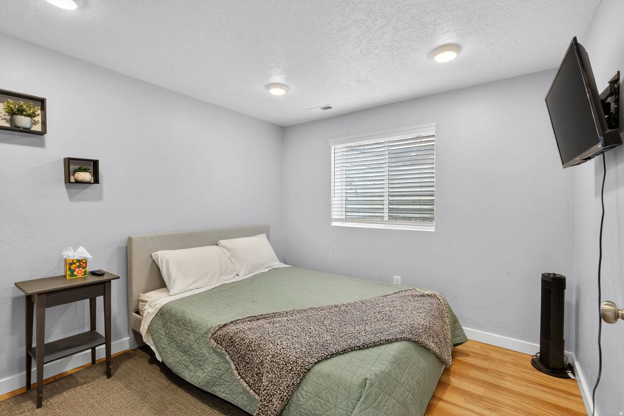 Bedroom featuring a textured ceiling and wood finished floors