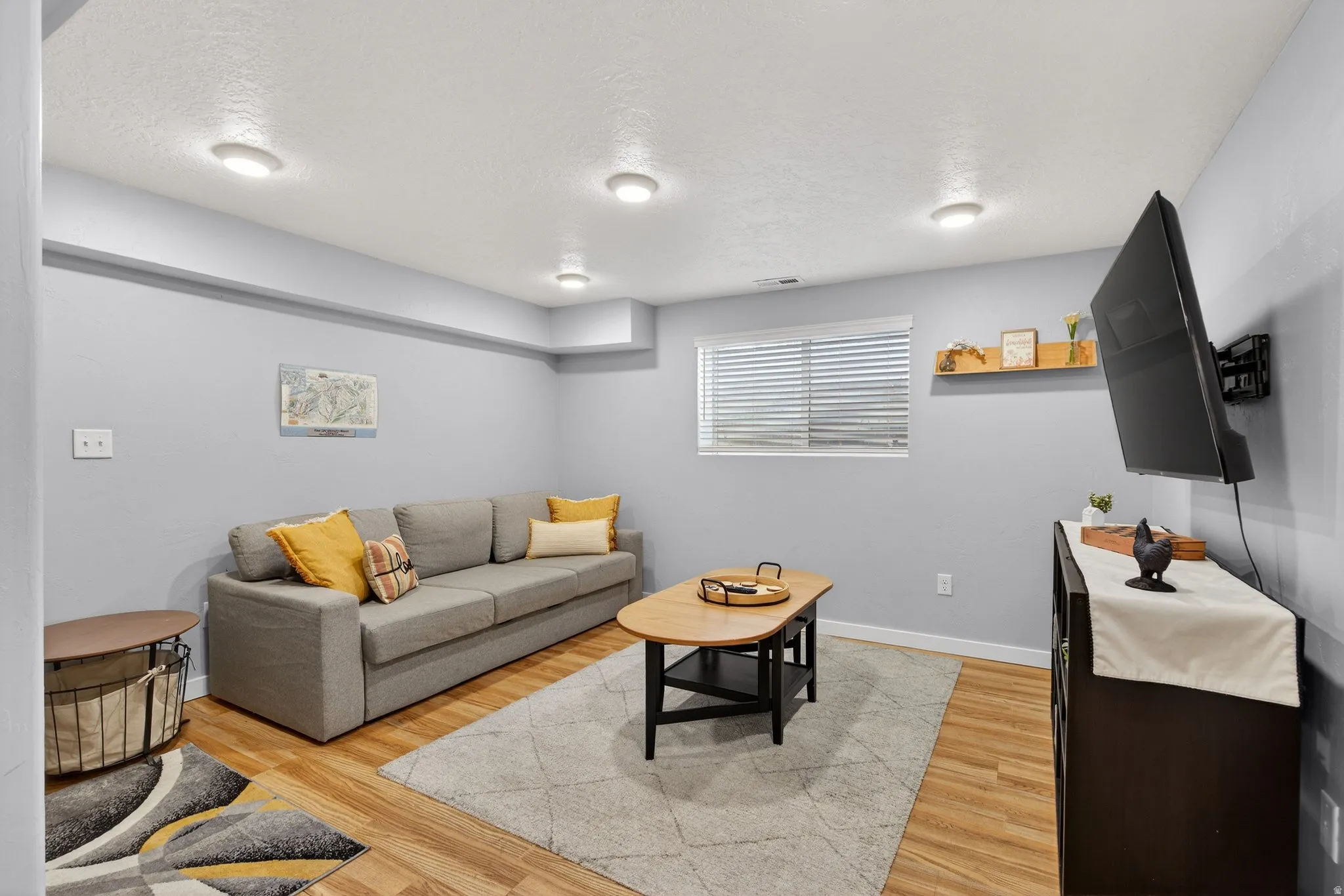 Living area featuring light wood-style floors and a textured ceiling