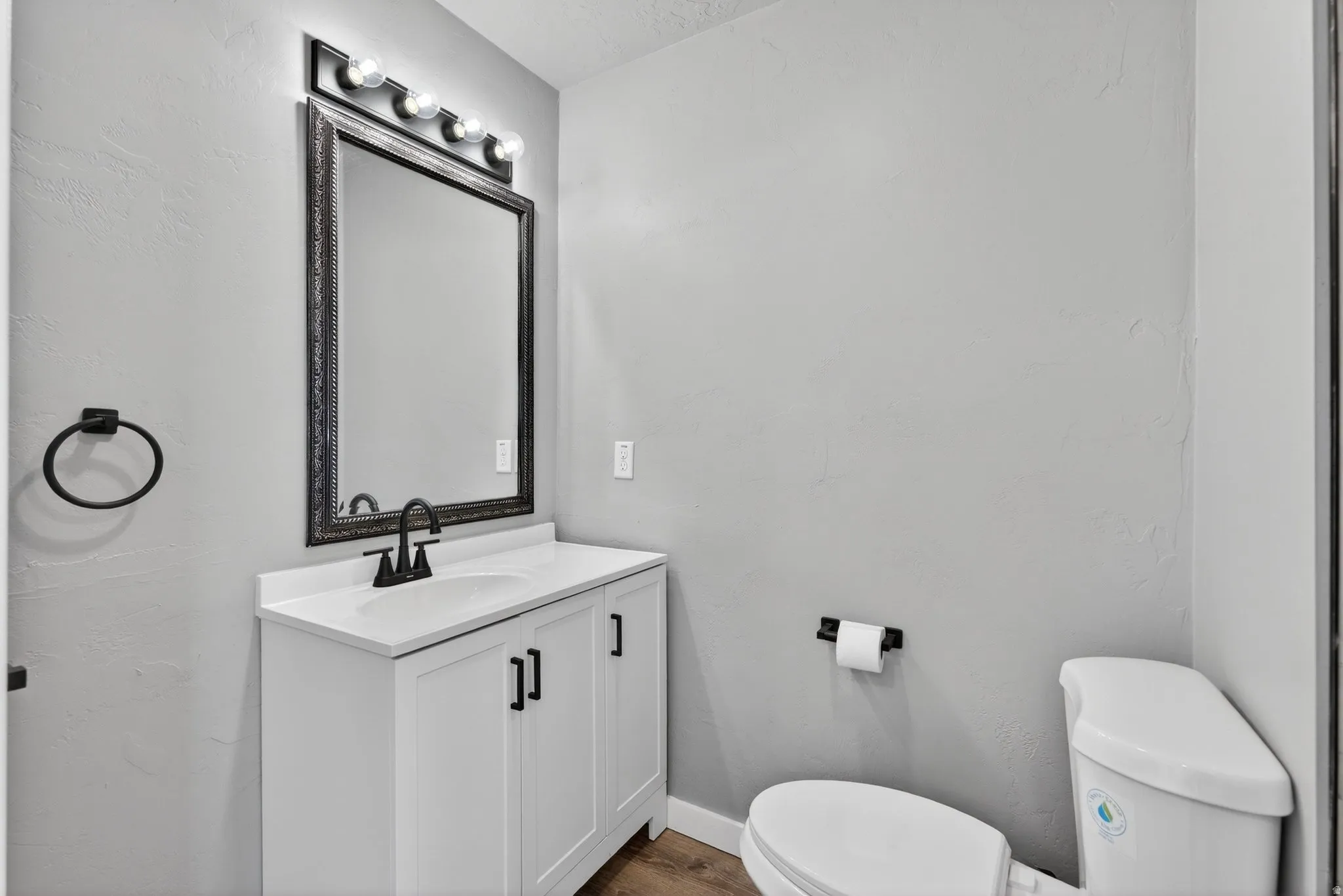 Bathroom featuring vanity, dark wood-type flooring, and a textured wall