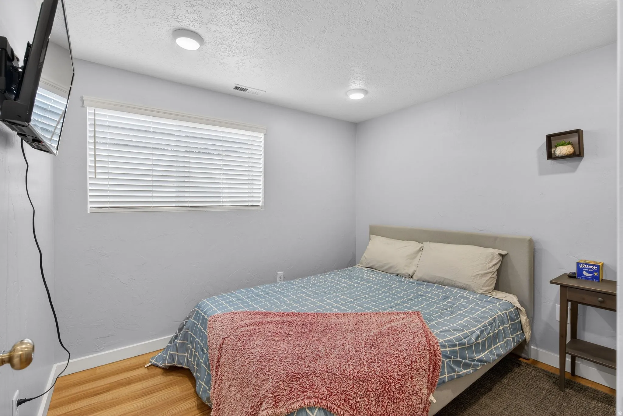 Bedroom featuring a textured ceiling and wood finished floors