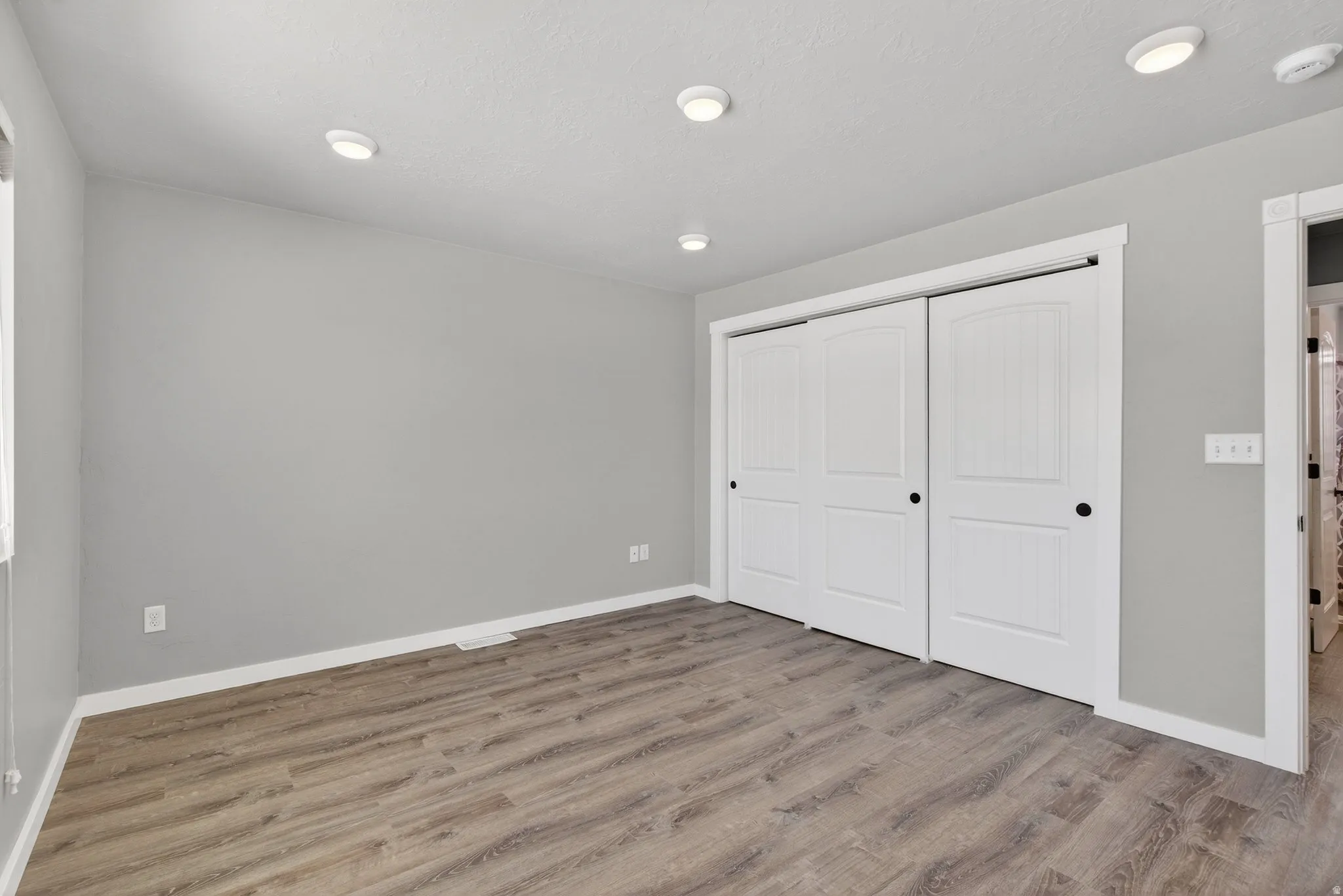 Unfurnished bedroom featuring a closet and wood finished floors
